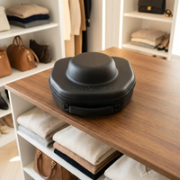 Voyager Hat Travel Case on a shelf beside folded knitwear